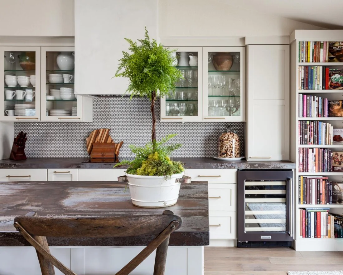 Îlot de cuisine en Dekton Trilium, avec un plan brun et gris devant des meubles blancs.