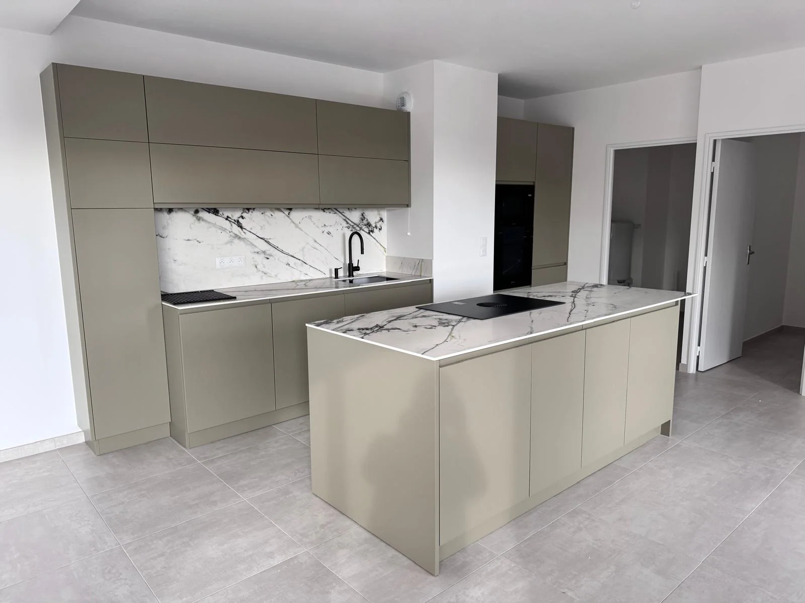 Cuisine vert olive avec îlot central et surfaces claires veinées