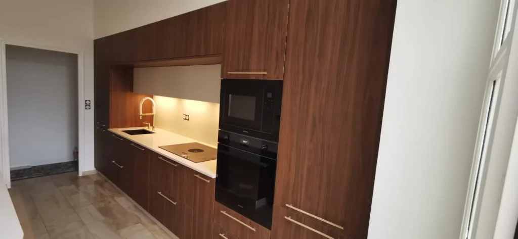 Cuisine en bois foncé avec plan clair et appareils intégrés