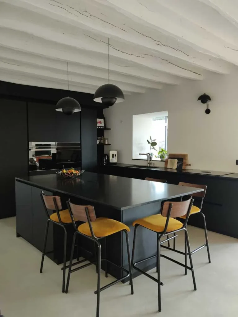 Cuisine noire ouverte avec îlot et assises